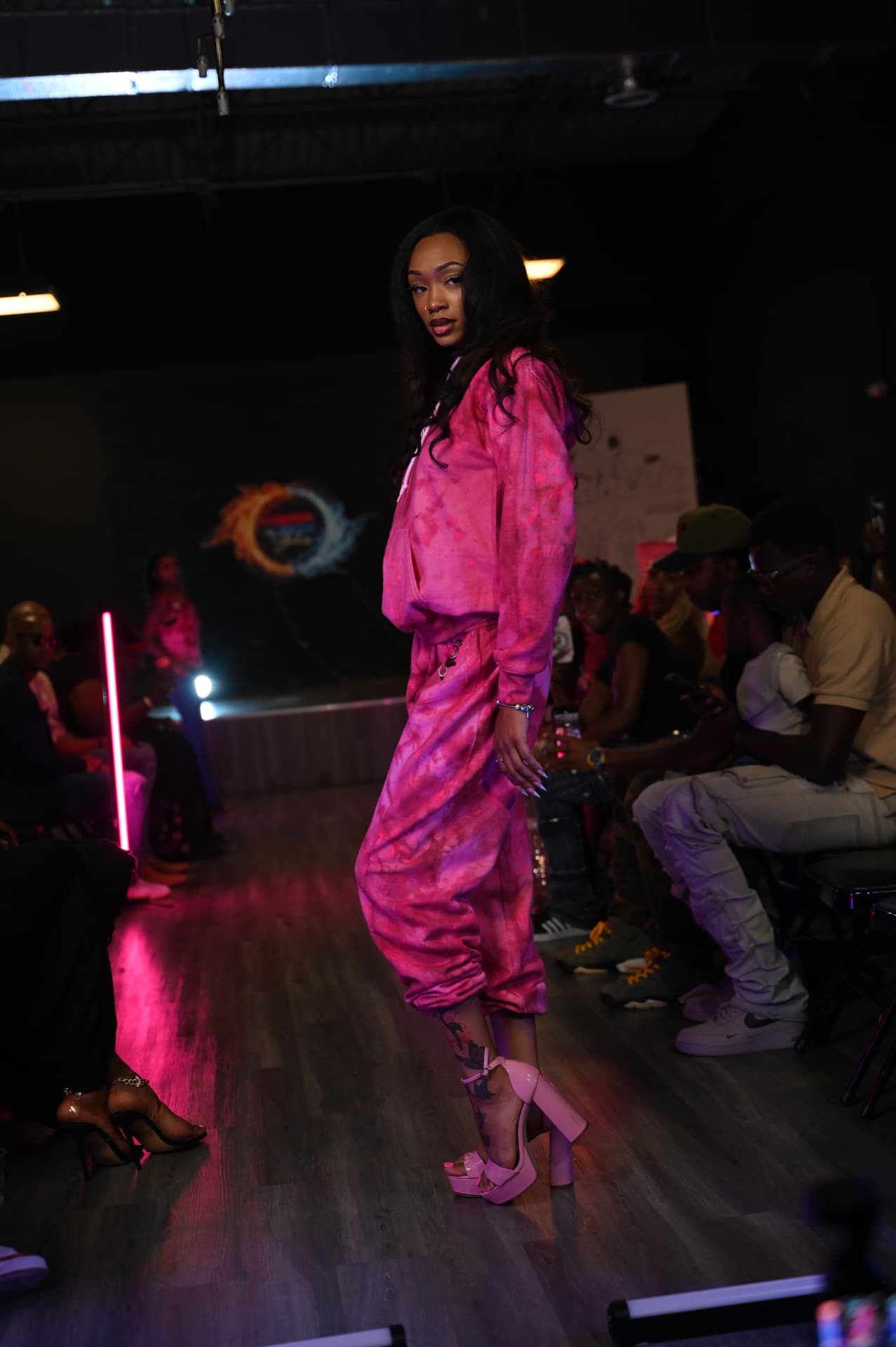 Kamyia on the runway in a pink satin set and platform heels