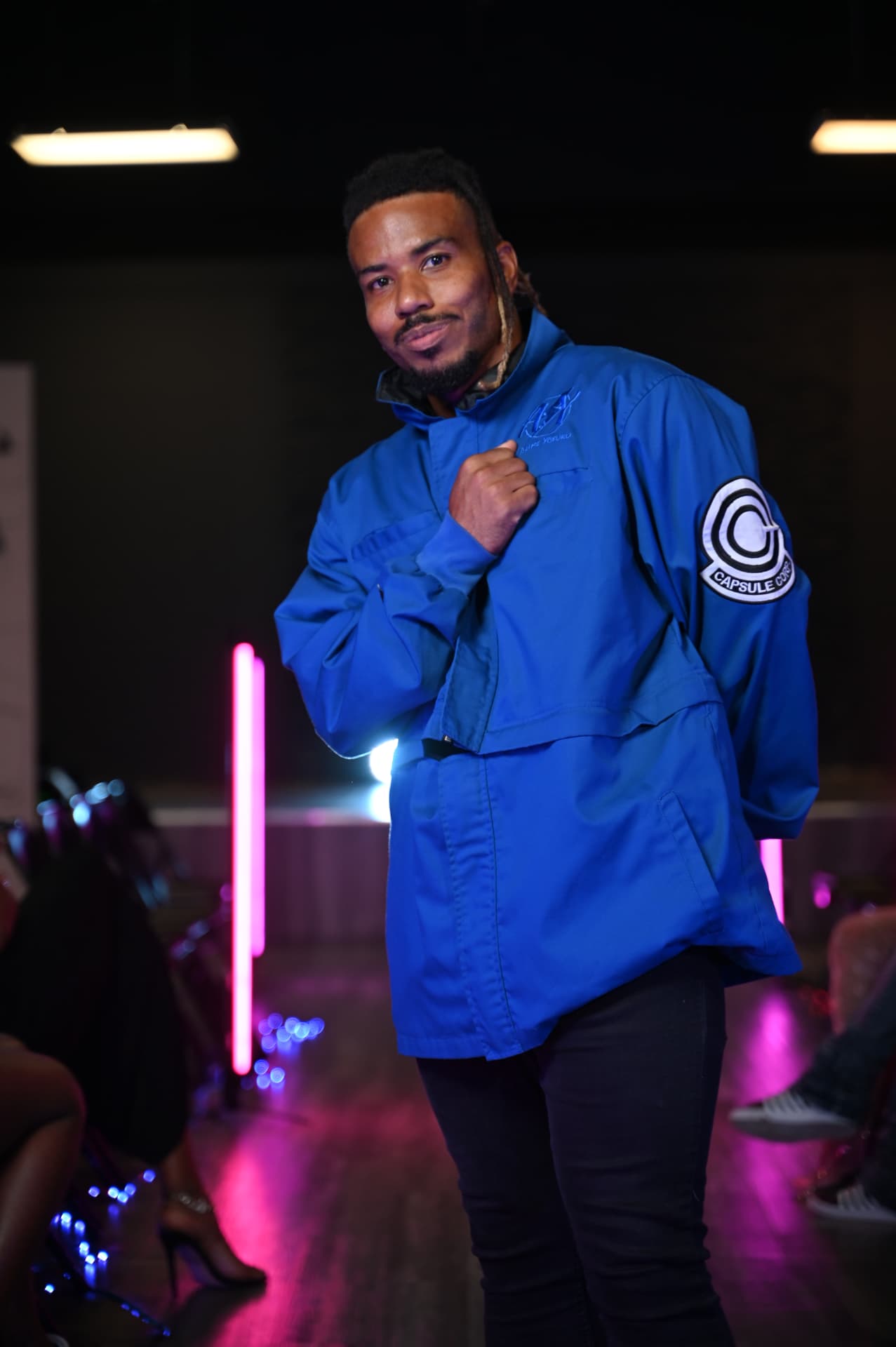 Gabriel on the runway in a blue jacket with pink neon lights